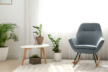 Interior of room with stylish armchair and houseplants