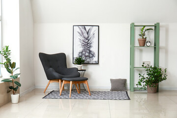 Interior of room with stylish armchair and houseplants near white wall