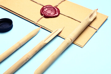 Supplies for calligraphy practice and envelopes on color background