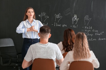 Teacher conducting courses for deaf mute people in classroom