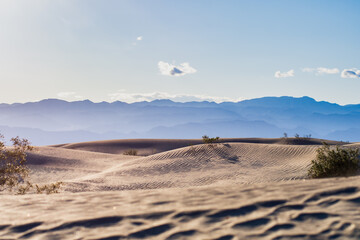 Sand dunes give way to layers of desert mountains 