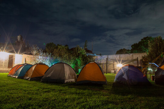 Tent camping relaxing on green lawn backyard