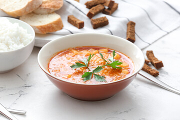 Bowl of tasty rice soup on table