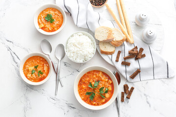 Bowls of tasty rice soup on white background