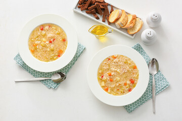 Bowls of tasty rice soup on white background