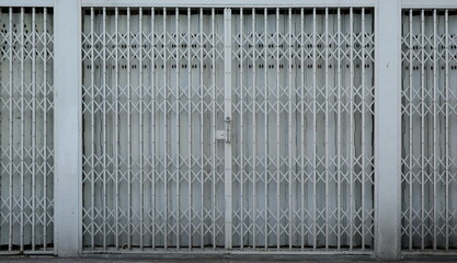 Vintage retractable folding metallic grill in front of a shop