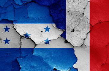 flags of Honduras and France painted on cracked wall