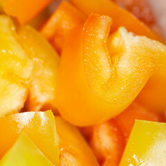 Juicy yellow and orange sweet pepper cut into slices, macro picture. 