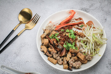 Chinese Steamed Rice Noodles with pork ,sausage,imitation Crab Stick,boil bean sprouts,mushroom and tofu in sweet soy sauce.Chili powder,pickled chili and sugar on table - asian food style
