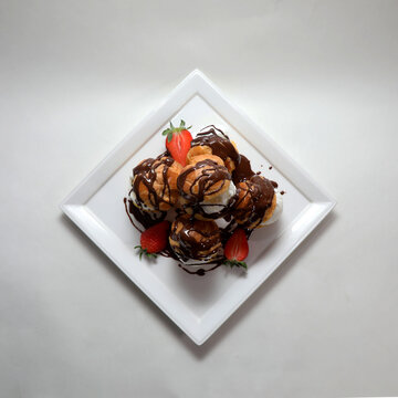 High angle shot of delicious dessert with ice cream and ekler