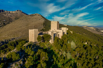 Fototapeta na wymiar Medieval Gothic Jaen castle with square towers, donjon on a hilltop above the largest olive groove in the world with dreamy cloudy blue sky