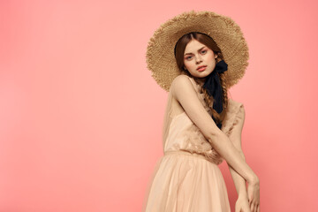 Fashionable woman in dress and hat with black ribbon on pink background cropped view of model emotions fun