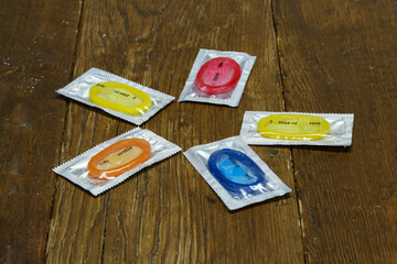 Closeup shot of packs of colorful condoms on a wooden table