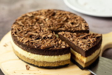 Fototapeta na wymiar Homemade triple layers chocolate bake cheesecake in round shape
