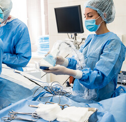 The surgeon uses a portable fluorescence imaging device during breast removal.