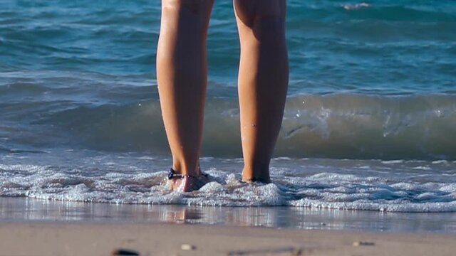 While the woman stands against the waves onshore in cesme izmir. Slow motion 1000fps