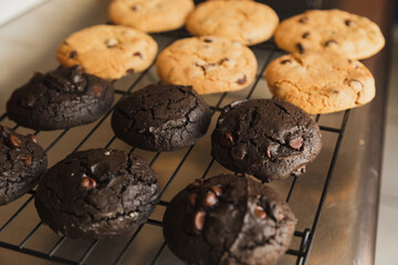 Chocolate chip cookies and cookies cooling on a wire rack - homemade cookies fresh from the oven