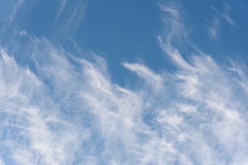 Fresh air, bright blue sky with wispy white clouds, as a nature background
