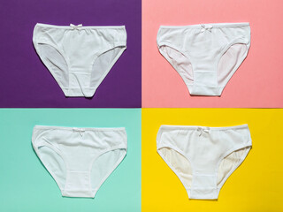 Set of four white women's panties on a multi-colored background. Flat lay.