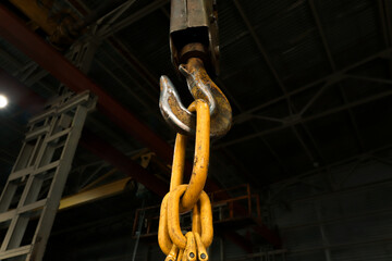 Yellow hook of a crane in the workshop of the plant.