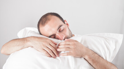 Caucasian man holding pillow. Sleeping man