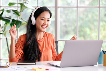 Happy asian women working online with laptop computer at home office, Asia female smiling and holding coffee cup while relaxing from working