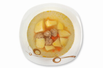 Delicious soup with meatballs and vegetables in a plate isolated on a white background.Top view.