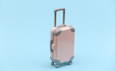 Travel or trip concept. Mini plastic travel suitcase on blue background. Minimal style