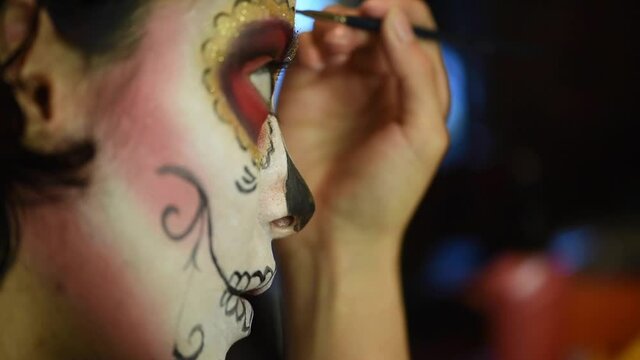 Mujer joven mexicana latina maquillaje catrina calavera d&iacute;a de muertos halloween tradicional festividades colorido esqueleto cara rostro blanco close-up