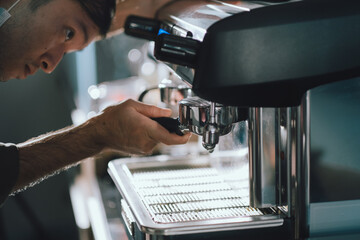Prepares espresso pouring from coffee machine in coffee shop at cafe
