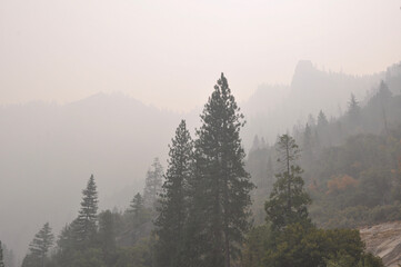 Very hazy and smokey view of mountains and trees from Yosemite Valley, during wildfire season