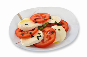 Delicious tomato salad with feta cheese on a plate isolated on a white background. Selective focus.