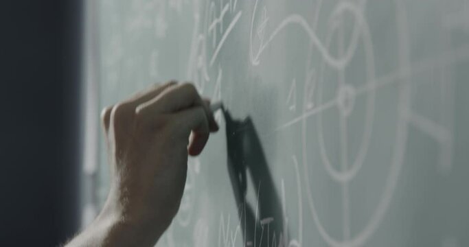 Creative mathematician writing formulas on the chalkboard