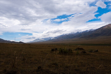 Mountain plateau with cloudy blue sky on background. Rural scenery. Summer nature landscape. Borokhudzir plateau, Kazakhstan. Tourism in Kazakhstan concept.