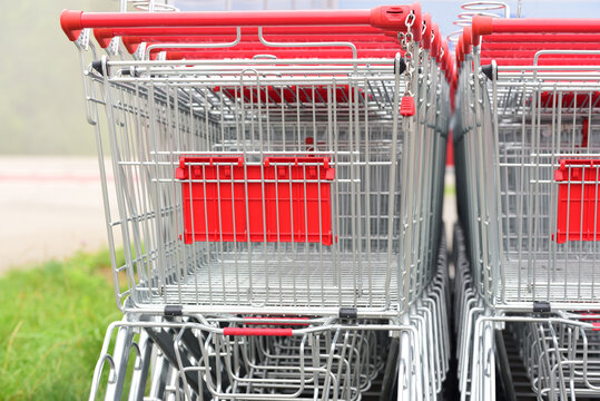 Close up of several silver shopping trolleys stacked one inside the other and photographed from behind