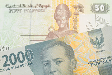 A macro image of a grey two thousand Indonesian rupiah bank note paired up with a green and yellow fifty piastre note from Egypt.  Shot close up in macro.