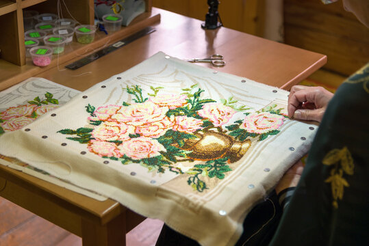 Girl doing embroidery vase with flowers