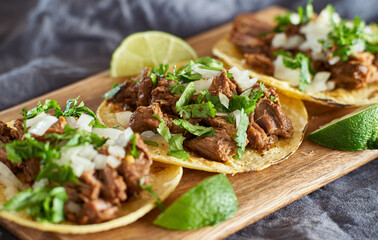 three carne asada mexican street tacos in corn tortilla with lime - 378032494