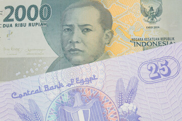 A macro image of a grey two thousand Indonesian rupiah bank note paired up with a blue twenty five piastre bank note from Egypt.  Shot close up in macro.