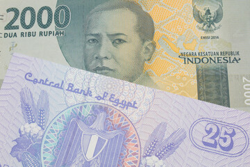 A macro image of a grey two thousand Indonesian rupiah bank note paired up with a blue twenty five piastre bank note from Egypt.  Shot close up in macro.