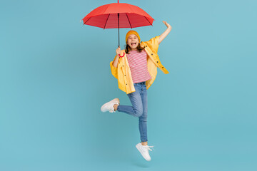 Kid with umbrella on colored background.