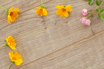 Top view of calendula and rose flowers on the wooden boards.