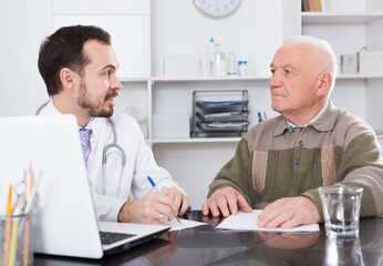 Elderly man comes to doctor in clinic for advice on health