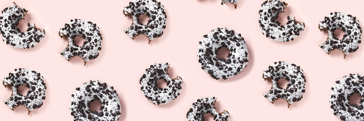 donuts on a pink background top view. Flat lay of delicious nibbled chocolate donuts. used as donut...