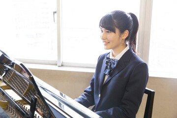 ピアノのを弾く女子高校生 © Paylessimages