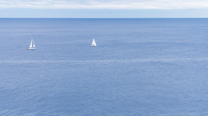 Two sailing boats sailing in the Mediterranean Sea on the Costa Brava.