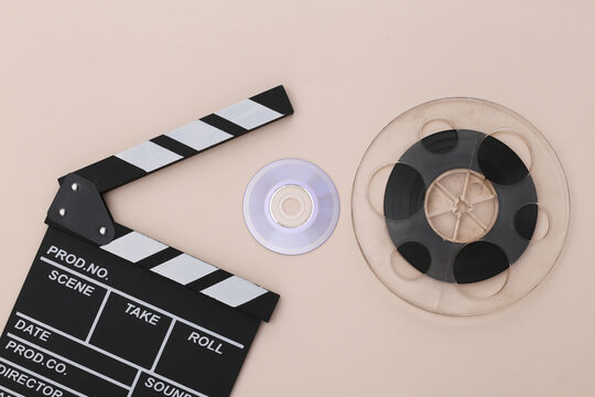 Movie clapper board, cd and film reel on beige background. Cinema industry, entertainment. Top view