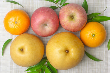 Apples, oranges, Chinese pear, auspicious fruit for worship in various ceremonies Placed on a cloth and with leaves