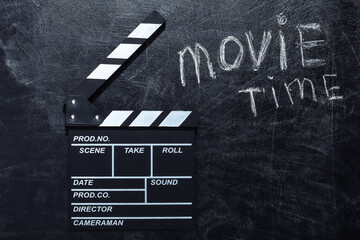 Movie time. Movie clapper board on chalk blackboard. Cinema industry, entertainment