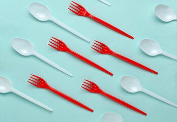 Top view of colorful forks and spoons on the bright blue background